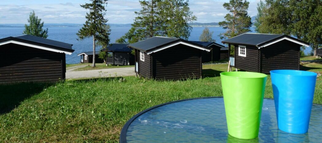 Campingplatz in Norwegen mit Hütten und Plastikbecher im Vordergrund