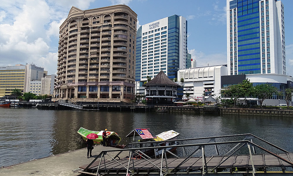 Hochhäuser und alte Boote in Kuching